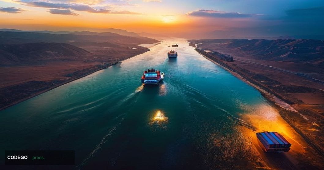 A dramatic aerial view of the Strait of Hormuz at golden hour, showing the narrow waterway between Iran and Oman with cargo s
