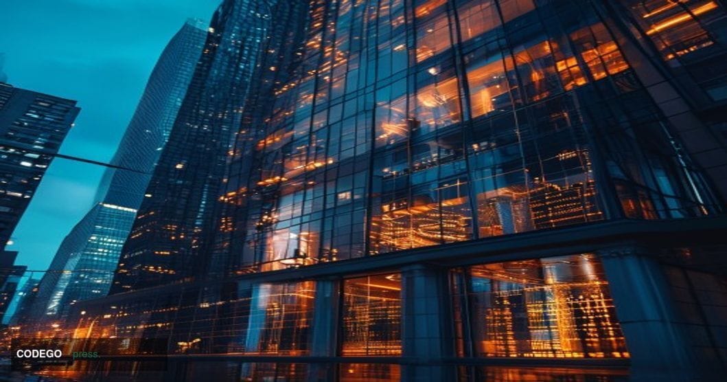 A cinematic editorial photograph of Kalshi's New York headquarters building exterior at dusk, with warm amber light spilling 