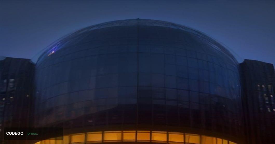 A cinematic editorial photograph taken from a low angle looking up at Amazon's iconic Seattle headquarters campus, the glass 