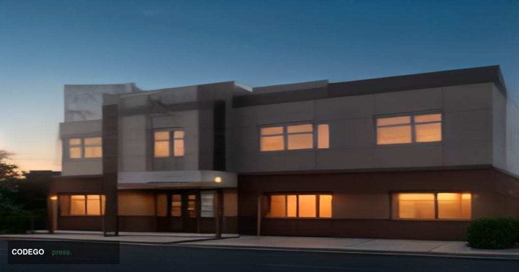 A photorealistic editorial photograph of a small American community bank branch exterior at dusk, with warm amber streetlight