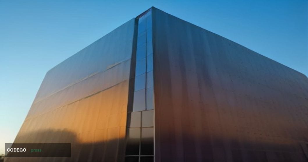 A wide-angle cinematic editorial photograph shot from a low angle looking up at a sleek, modern glass-and-steel corporate cam
