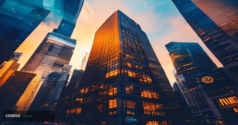 A dramatic editorial photograph showing the iconic BitMEX headquarters building in Hong Kong's Central district at golden hou