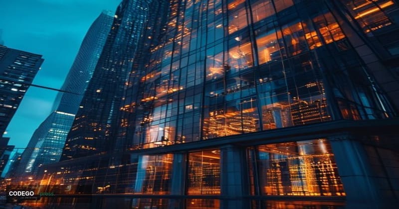 A cinematic editorial photograph of Kalshi's New York headquarters building exterior at dusk, with warm amber light spilling 