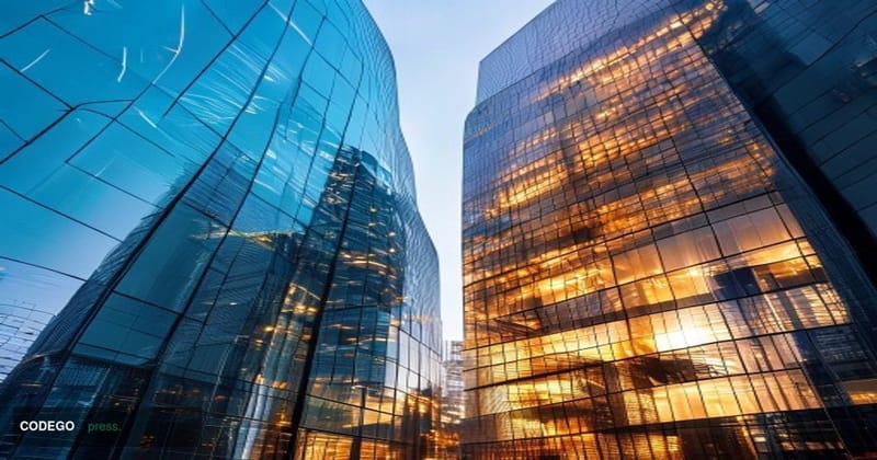 A cinematic editorial photograph shot from a low angle looking up at the glass and steel facades of two distinct financial te