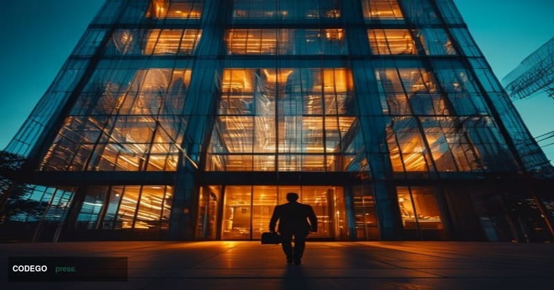 A cinematic editorial photograph taken at street level looking up at the Coinbase headquarters building exterior in San Franc