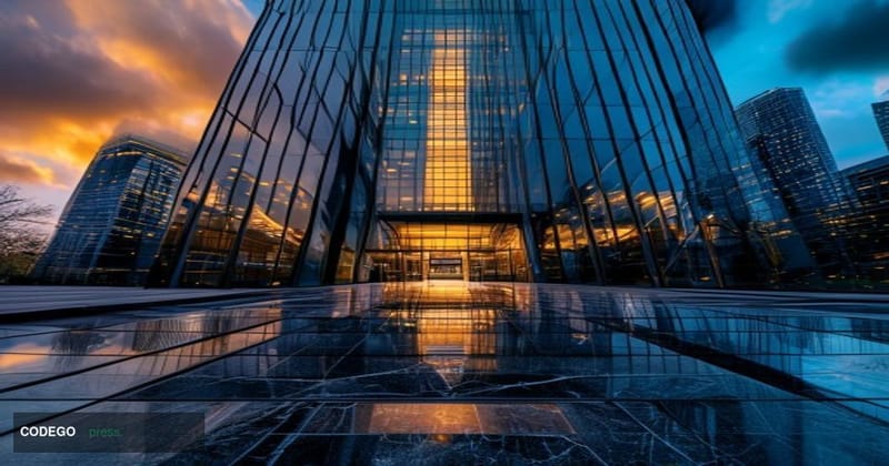 A cinematic editorial photograph taken at ground level looking up at a modern corporate financial district tower, with "Delux