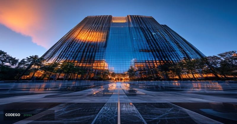 A dramatic cinematic editorial photograph taken at ground level looking upward at a modern corporate headquarters building in
