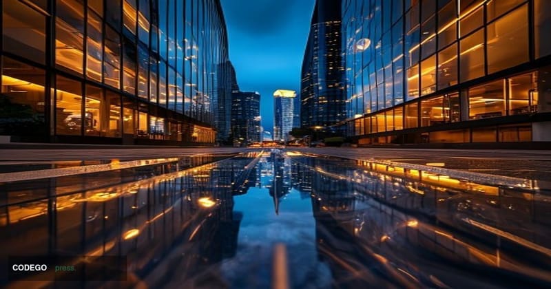 A photorealistic editorial photograph shot from a low angle at dusk, looking up at the glass-and-steel facade of a modern Sou