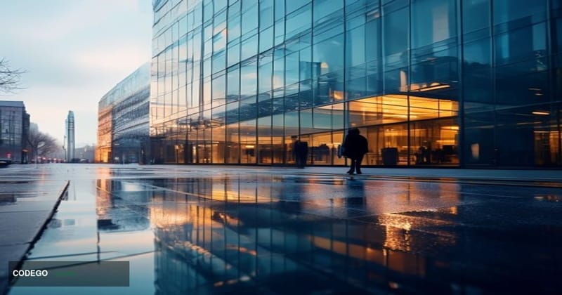 A cinematic editorial photograph of a modern glass-and-steel office building in central London on an overcast morning, identi