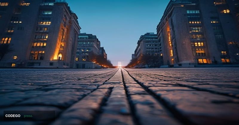 A cinematic editorial photograph shot from a low angle looking up at two imposing government buildings facing each other acro