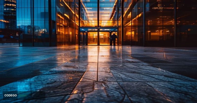 A cinematic editorial photograph centered on a modern glass-and-steel fintech corporate office exterior, shot from a low angl