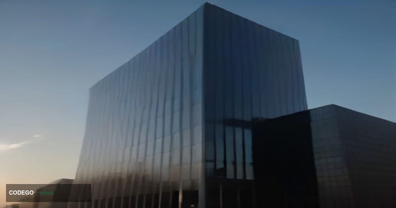 A cinematic editorial photograph of a monumental glass-and-steel bank headquarters at dawn, shot from a low angle looking upw