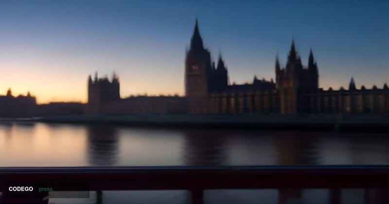 A cinematic editorial photograph set in Westminster, London, with the iconic silhouette of the Houses of Parliament and the T